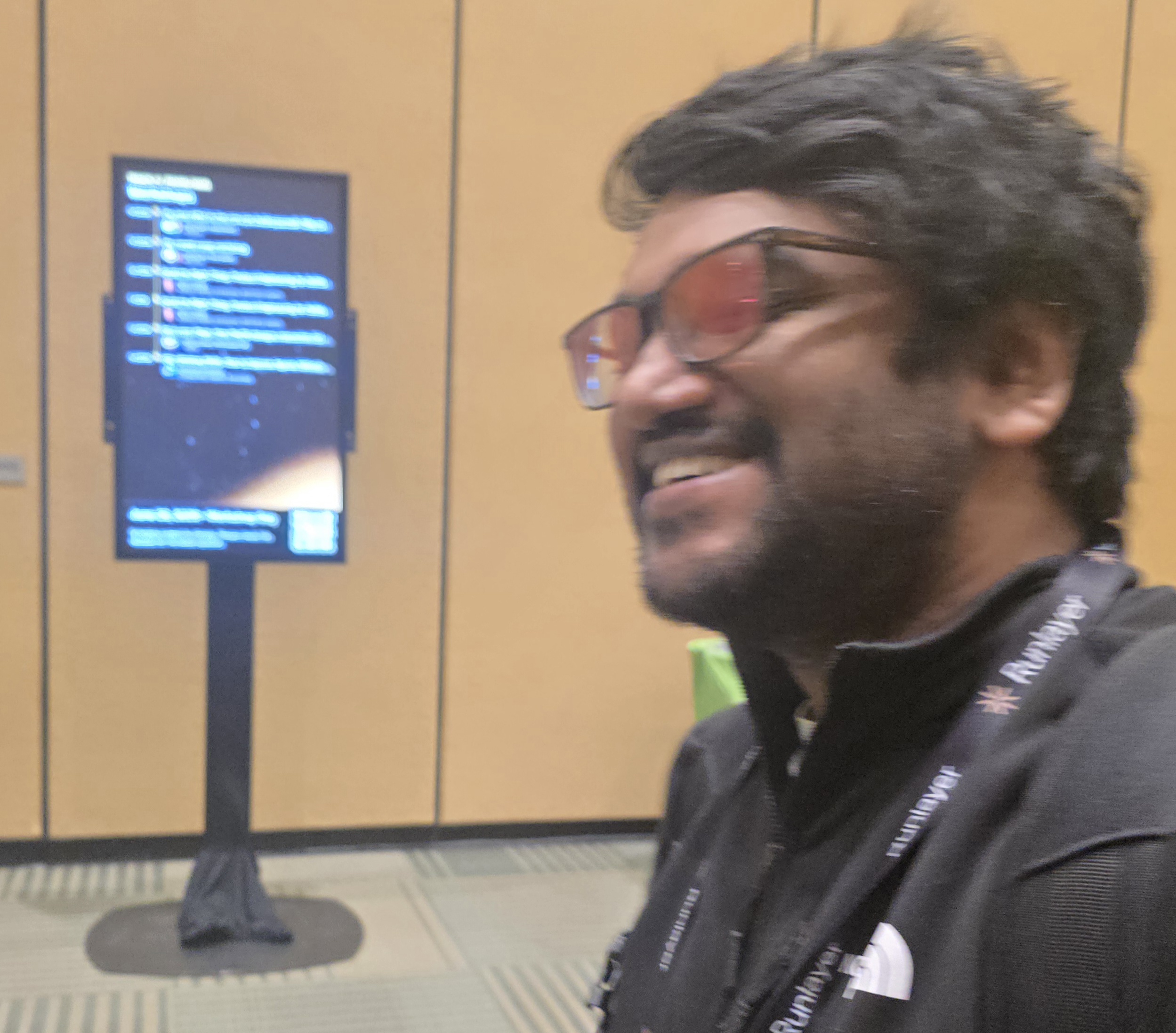 A workshop attendee laughing near a live code demo screen