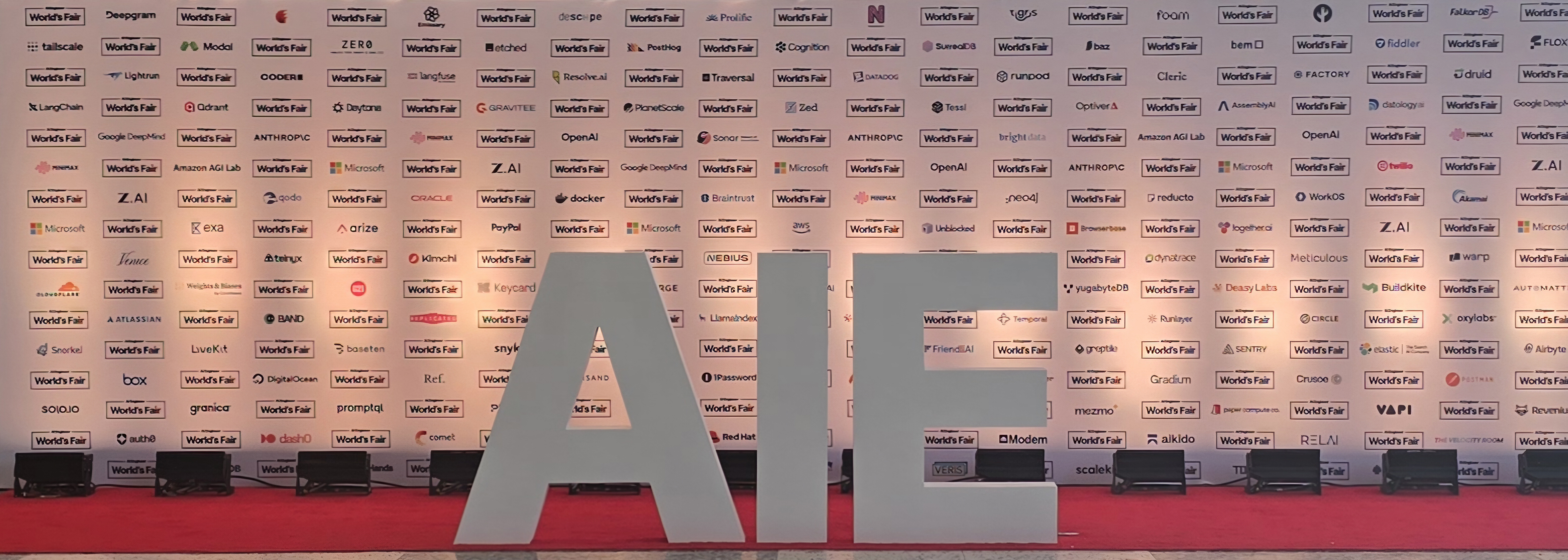 AI Engineer World's Fair sponsor wall and step-and-repeat backdrop with the AIE letters