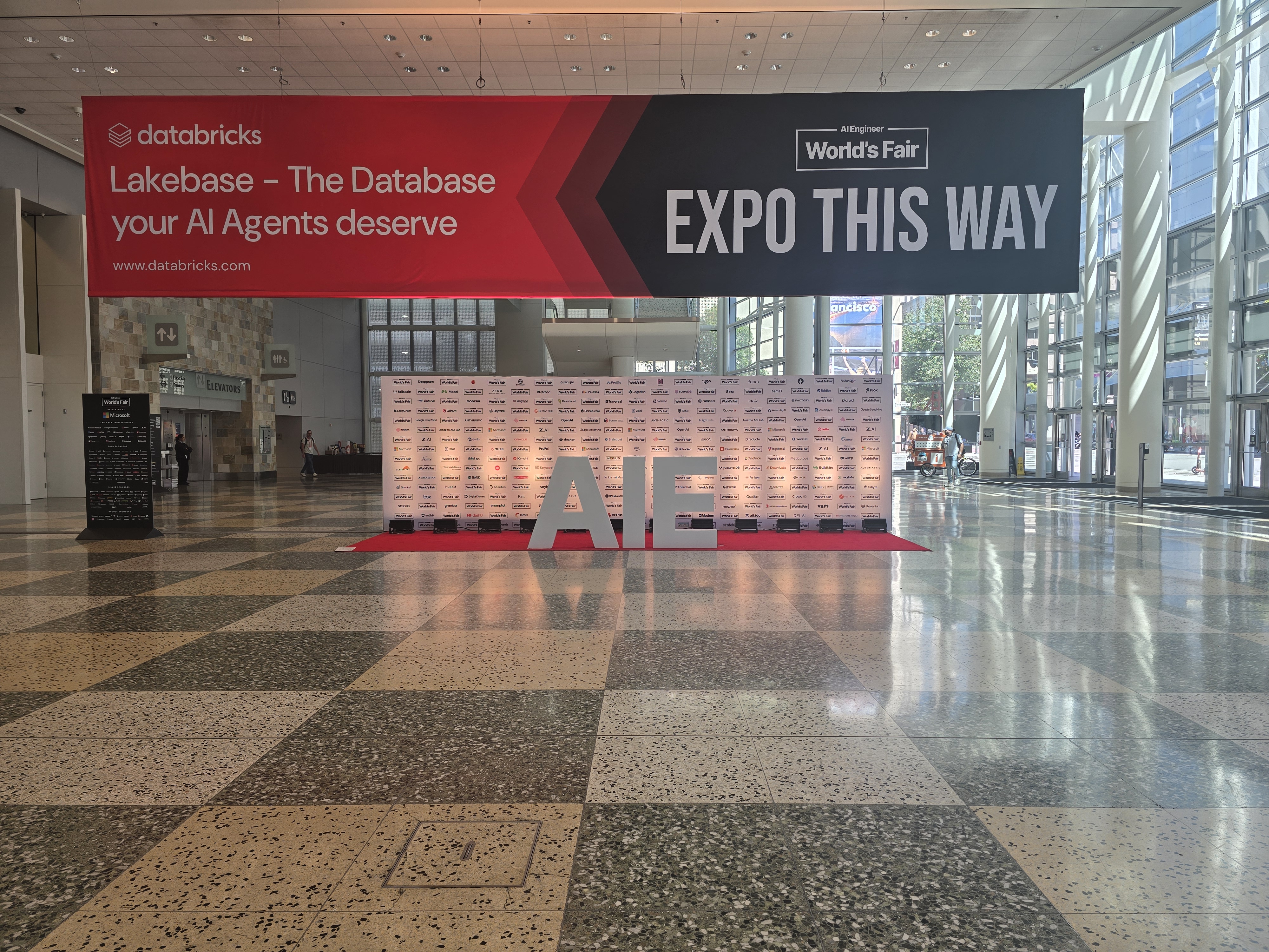 Moscone West lobby with a Databricks banner and Expo This Way sign
