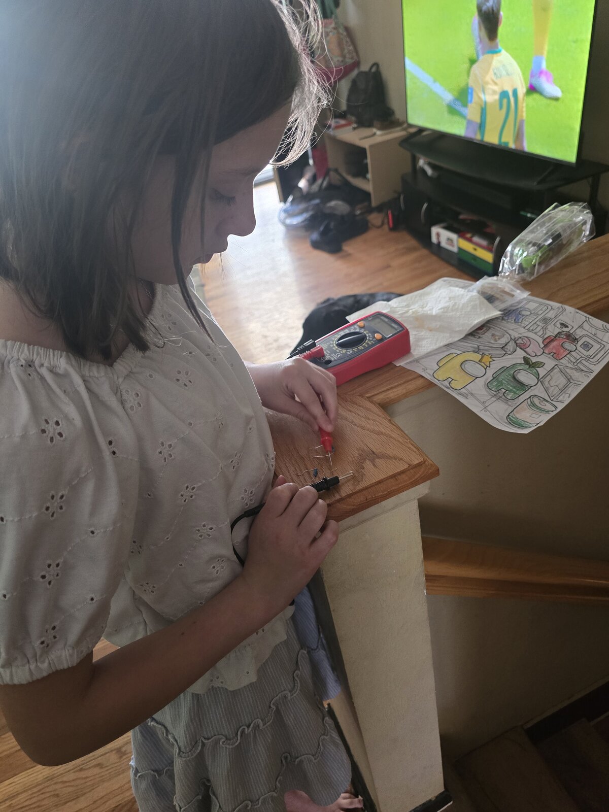 pixie_technologist using a multimeter on a small circuit at home